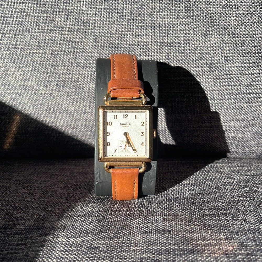 Shinola square face gold and cognac leather watch.